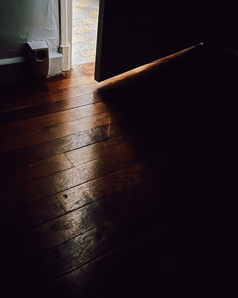 Porte entrouverte avec ombre sur le parquet pour le challenge des 100 jours de lumière 