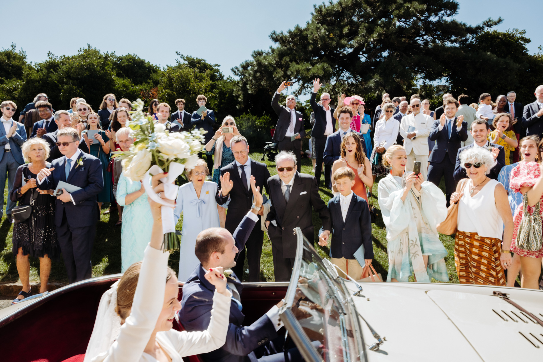 Depart des mariés en voiture devant tous leurs invités
